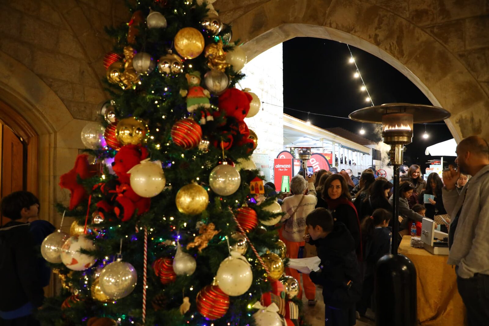 A decorated Christmas tree beside market stalls